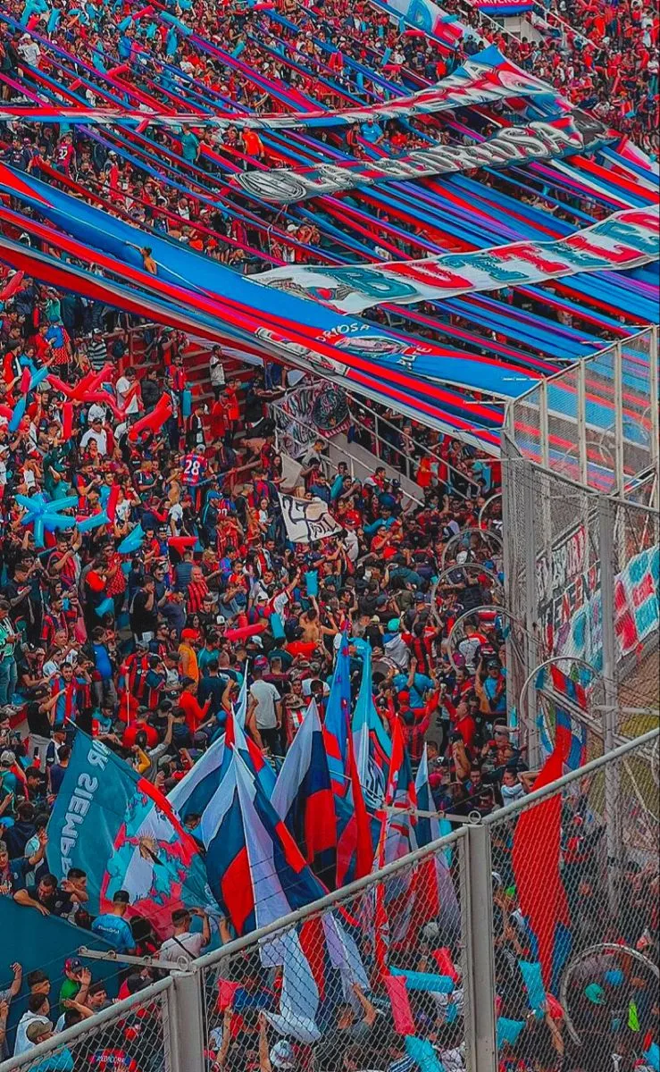 Tribuna llena de banderas azules y rojas